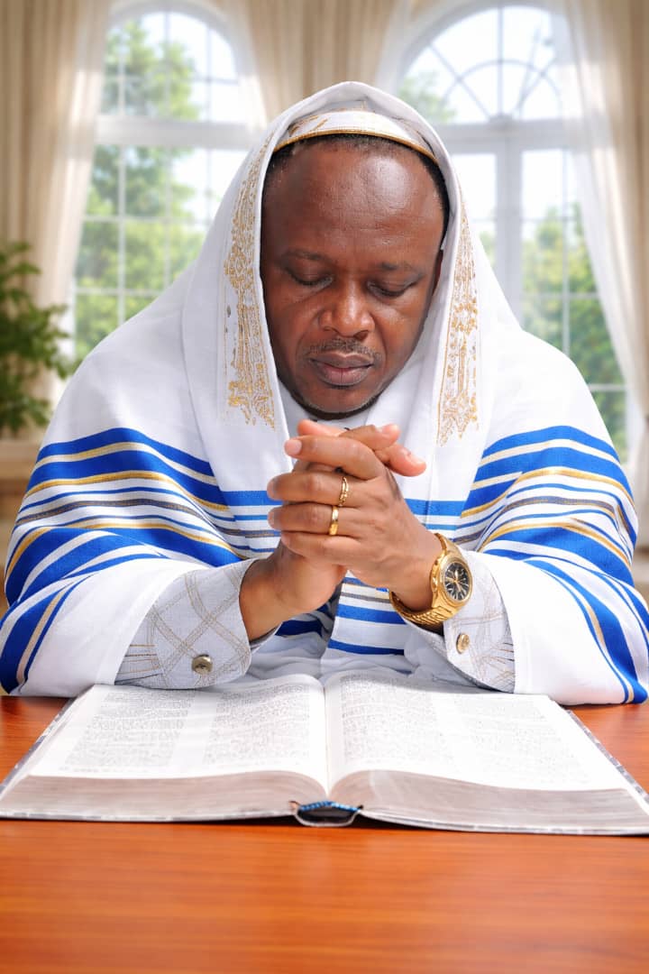Pastor Goodluck praying over Scripture